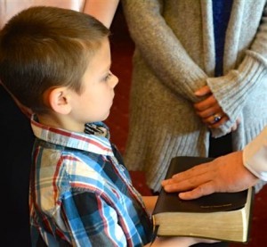 Jay Suydam holds the Bible as his father, Jason Suydam, is promoted to lieutenant in the Chester County Sheriff’s Office.