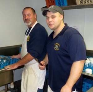 Deputy Sheriffs Dave Reeves (left) and Ben Tobin display their dish-washing prowess in the kitchen.